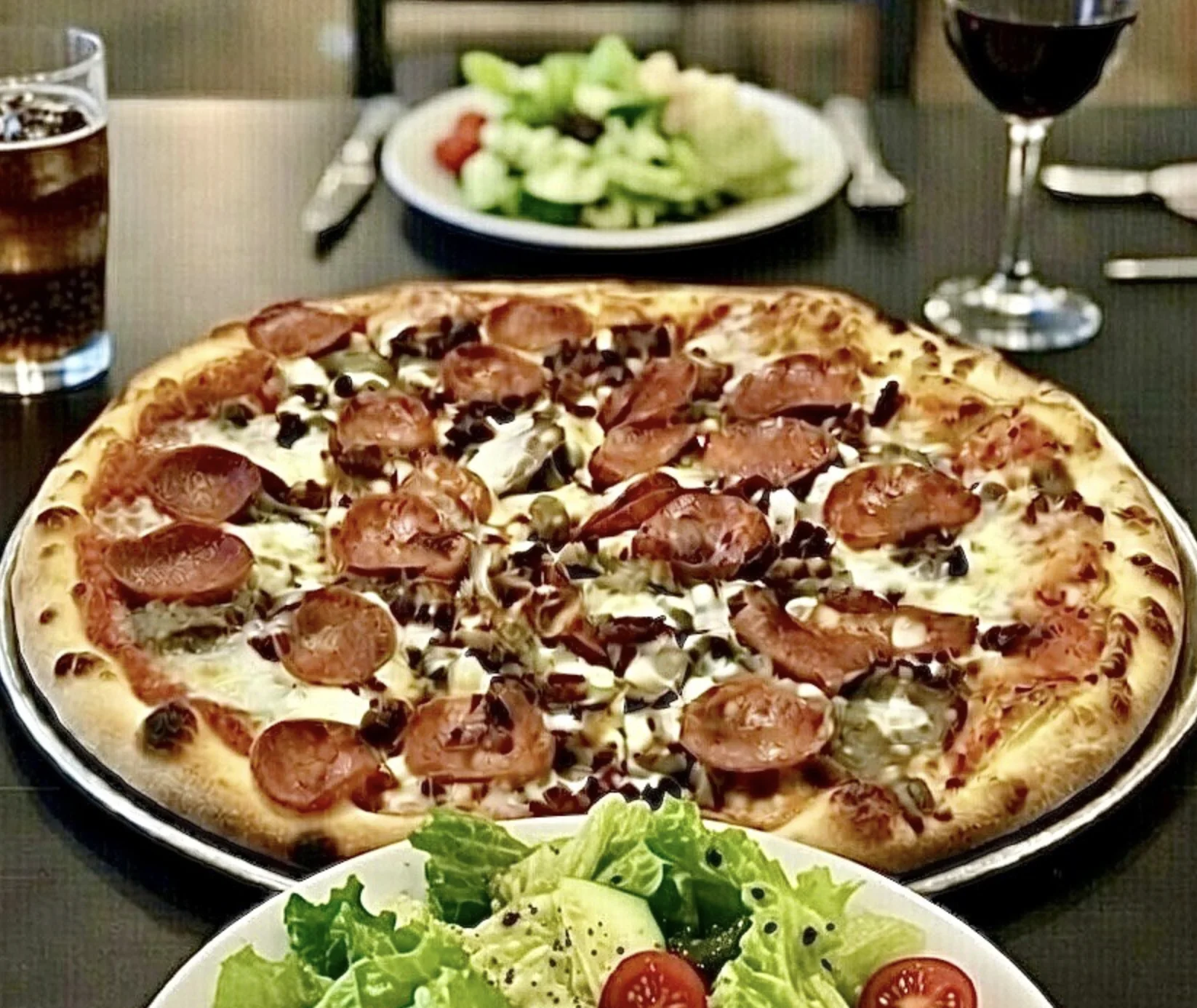 A loaded specialty pizza served with fresh salads